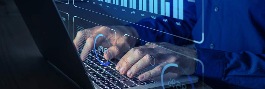 Close up of hands on a laptop with computer imagery of bars and charts floating in front of the user