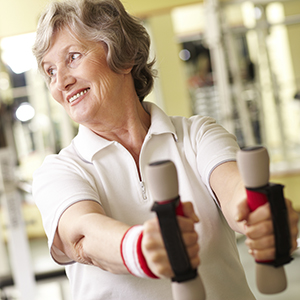 mature woman lifting weights and smiling